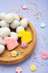 Gingerbread Easter figures - rabbit with easter egg on purple background. Happy Easter, spring concept. Vertical photo