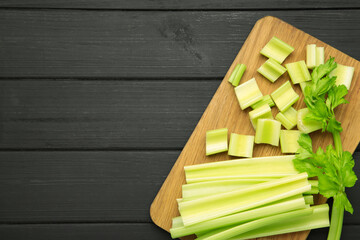 Fresh green cut celery on black wooden background