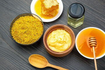 Fresh flower honey of different varieties, pollen and honeycomb with spoons on a wooden background....