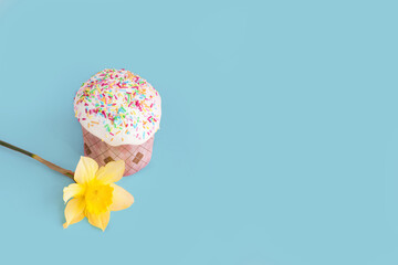 Traditional russian Easter ortodox cake with daffodil flower and colorful eggs on light pink background. Kulic, Kulich, Paska homemade bread with glaze. Spring christian holiday. Festive celebration