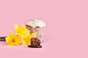Traditional russian Easter ortodox cake with daffodil flower and colorful eggs on light pink background. Kulic, Kulich, Paska homemade bread with glaze. Spring christian holiday. Festive celebration