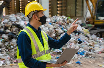An engineer in a high-visibility vest and safety helmet monitors recycling operations, optimizing...