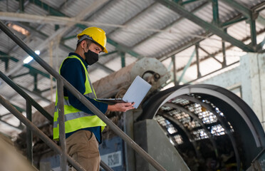 A waste management professional monitors waste sorting operations at a recycling plant, ensuring compliance with environmental sustainability standards.