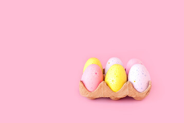 Eco basket with colorful easter eggs on pastel light pink background. minimalistic decoration, minimal composition. Front view, place for text, banner
