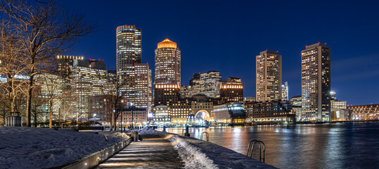View of Boston downtown  skyscrapers seen from Fan Pier Park on a cold cloudy winter night