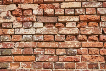 Old red brick wall background, uneven brickwork