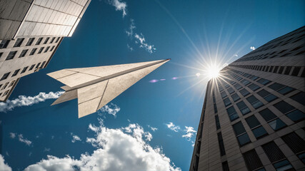 Paper airplane flying between skyscrapers