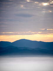 Mountain Range Emerging from Morning Mist at Sunrise