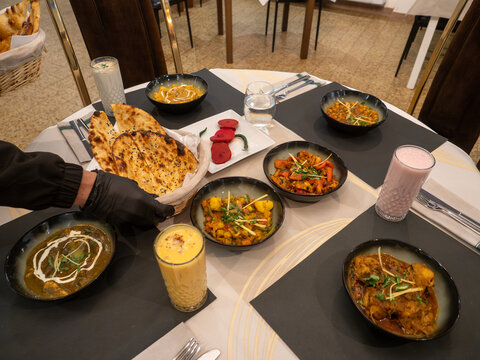Waiter serving traditional indian food in a restaurant