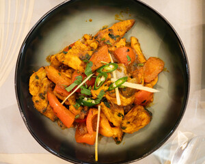 Spicy chicken tikka masala with vegetables, ginger and coriander, served in an elegant Indian restaurant