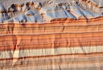 Obraz premium Exposed strata of clay, showing various earth layers in a quarry, surface, orange