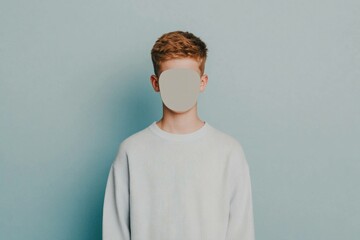 A young model in a light sweater stands against a soft blue background, conveying a calm and serene emotion, perfect for modern lifestyle concepts