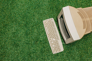 Vintage PC on green grass, top view. Monitor and keyboard as in 90s