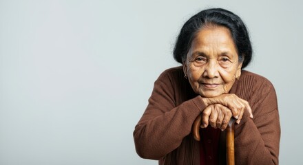 Elderly asian woman smiling while leaning on cane