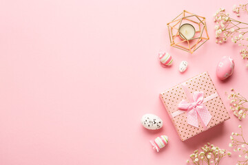 Easter composition on pink background. Easter eggs, flowers, gift box. Flat lay with copy space.