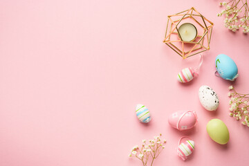 Easter eggs background on pink. Colored eggs, flowers. Flat lay with copy space.