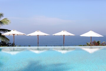 Beach umbrella reflection in water. India. Indian Ocean. Kerala. Sea view background. 2024.