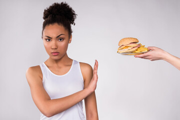 Black girl refusing cheeseburger isolated.