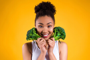 African American girl holding broccoli isolated.