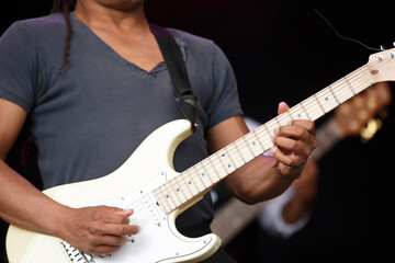 Musician performs live on stage during an outdoor concert showcasing skillful guitar playing and engaging audience in summer festival atmosphere
