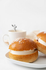Traditional Finish sweet buns with whipped cream for Shrove Tuesday. Laskiaispulla with a cup of coffee.