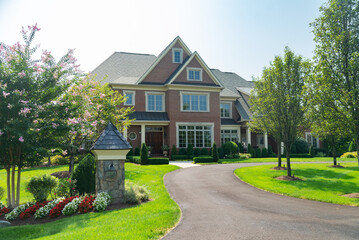 Landscape with large country house. Driveway for car. Green trees in the garden.