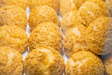 A beautifully designed restaurant communal space features sleek wooden benches positioned near a floor-to-ceiling glass facade, allowing natural light to flood the area. The warm tones of the wood