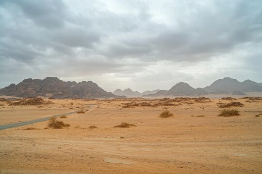 Barren desert landscape with mountain ranges and a stormy sky