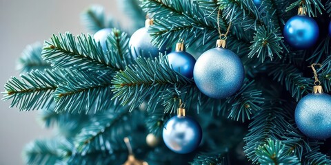 A lush Christmas tree branch adorned with shimmering blue and silver ornaments, blue and silver, christmas theme