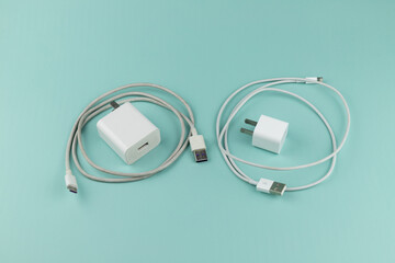 New and old mobile phone chargers on green background