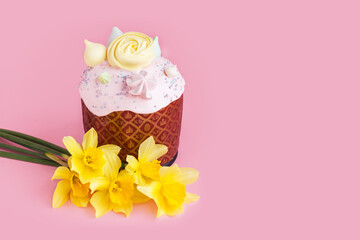 Traditional russian Easter ortodox cake with daffodil flower and colorful eggs on light pink background. Kulic, Kulich, Paska homemade bread with glaze. Spring christian holiday. Festive celebration
