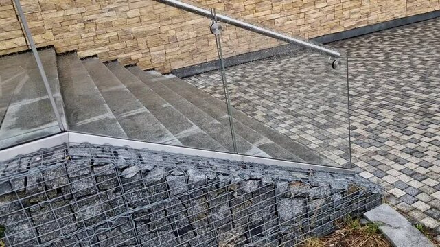 glass is attached to the wall using screws and washers intended for drilling into glass. the cladding is a railing and an air partition in the station hall, street, luxury