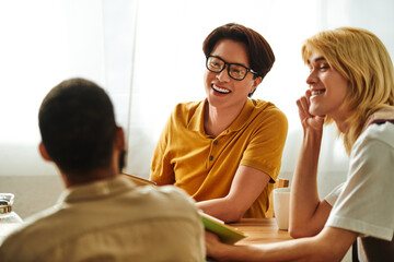 Fototapeta premium Engaging discussions among young men in a cozy book club setting at home