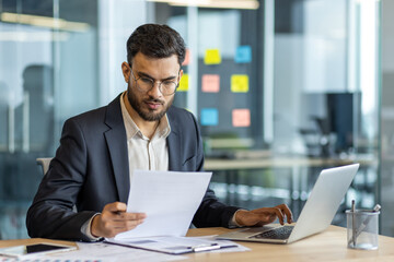Serious thinking businessman behind paperwork, man checking financial and investment reports....