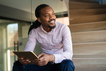 Smiling busy young African American business man, manager using tablet computer