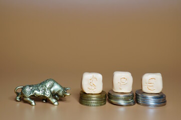 Dollar, ruble and euro icons. There is a bull figurine next to it.