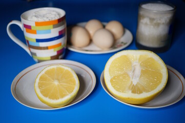 Grapefruit, lemon, eggs and a glass of sugar and flour on the table. Ingredients for the pie.