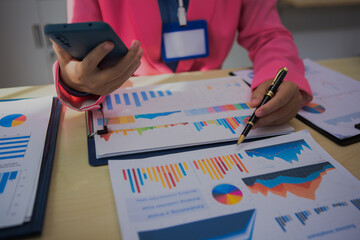 An Asian woman in a pink shirt confidently presents business results, highlighting growth, achievements, and key metrics, demonstrating strong leadership and clear communication to drive success