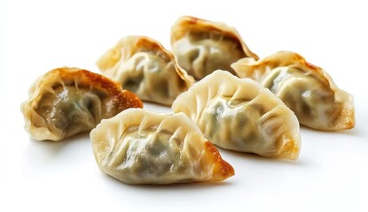 Several pan - fried dumplings with a slightly crispy, golden - brown edge on some parts, placed on a white background. 
