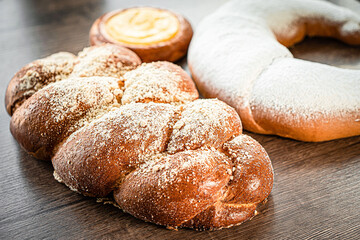 Braided buns bread decorated with sugar above on a wooden table background