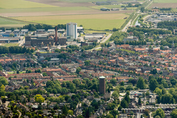 Fototapeta premium View of Zevenbergen showcasing residential areas, industrial structures, and surrounding landscapes on a clear day