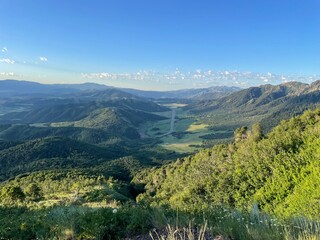 View overlooking highway running through Sardine Canyon and Dry Lake with mountain pine forests on each side from Wellsville Mountains in Utah USA © Tedi S Photography