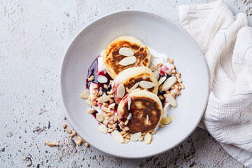 Syrniki with jam, sour cream and nuts.