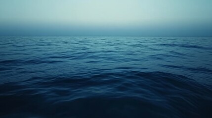 Obraz premium Calm sea surface with a painterly gradient of deep navy and sky blue, rippling subtly in the light.