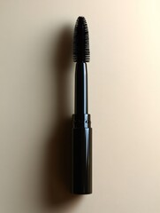 Obraz premium Black mascara brush casting a shadow on beige background