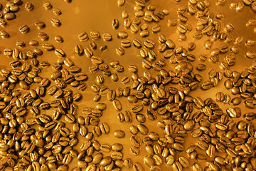 Stunning golden coffee beans are beautifully spread across a richly textured background that enhances their appeal. Golden Coffee Beans Displayed Beautifully on a Rich and Inviting Background Surface