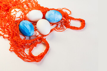 Mesh shopping eco bag, white and blue eggs on white or gray background. Easter holiday greeting card concept. Cotton knitted eco-friendly zero waste shopper. Flat lay, top view, place for text, banner