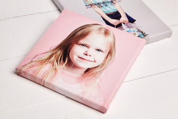 Two stretched canvas prints with gallery wrapping, featuring portraits of a smiling young girl. The...