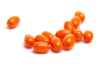 A collection of bright orange sea buckthorn berries with a smooth, glossy texture, scattered on a white background. Rich in antioxidants and commonly used in health foods