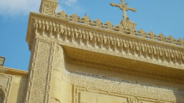 Ornate decorated gate of ancient Byzantine-Coptic church in Old Cairo. Main gates and facade of historical landmark: Saint Virgin's Mary Coptic Orthodox Church with carved decorations and coptic cross